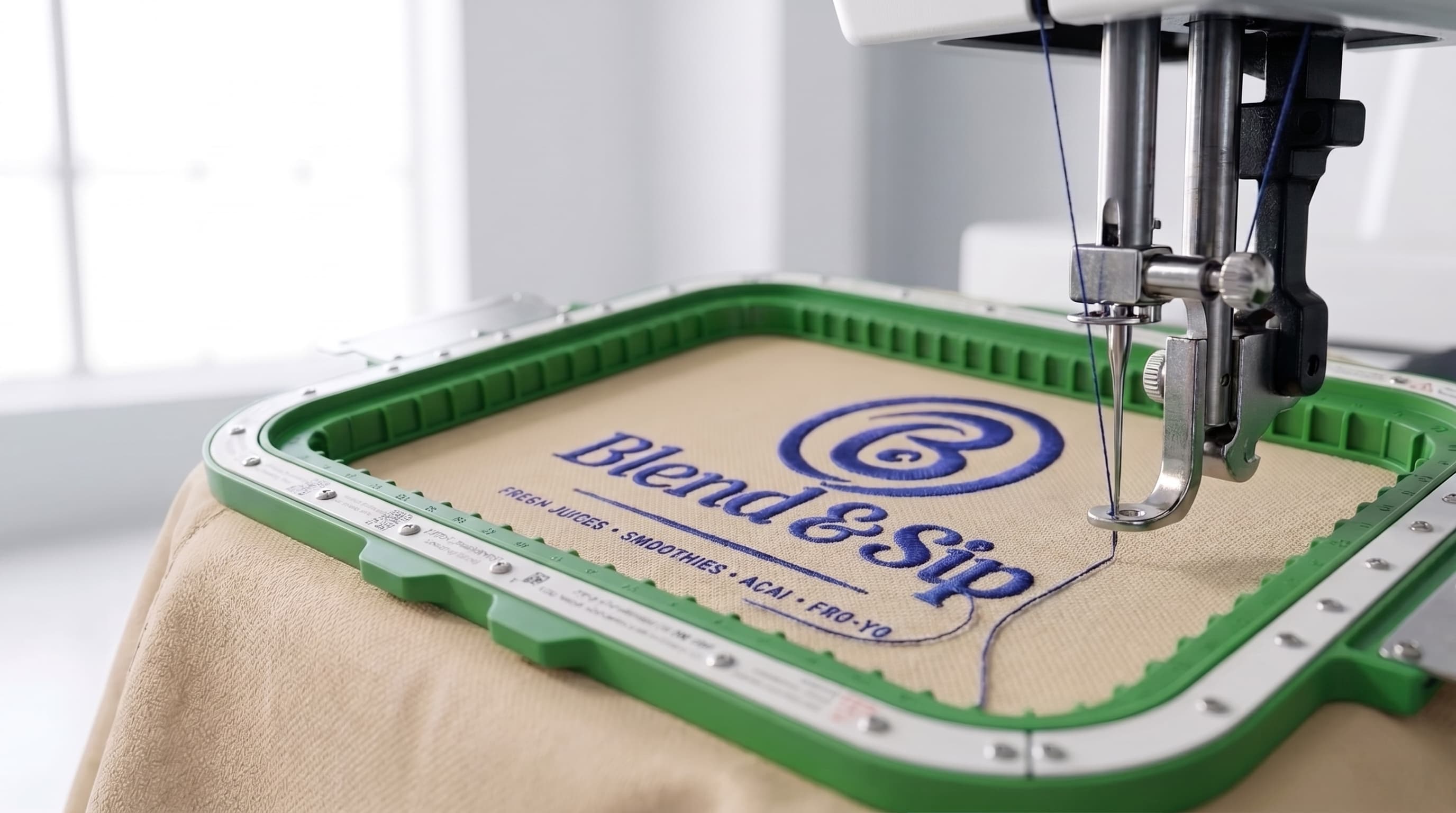 Commercial computerized multi-head embroidery machine stitching custom logo on green hoop frame